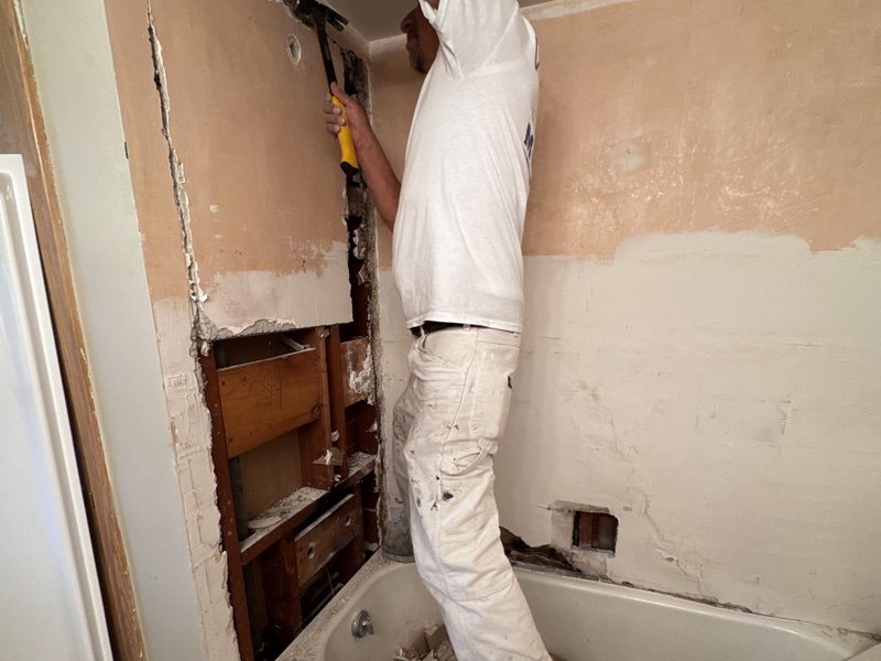 Drywall repair in progress inside a bathroom