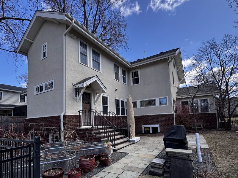 Rear exterior of a beige two-story home after painting