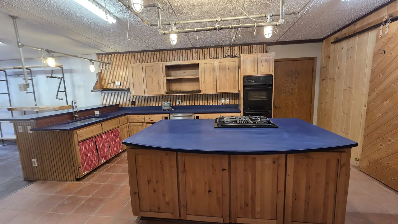 Kitchen with knotty pine cabinets, blue countertops and a center island