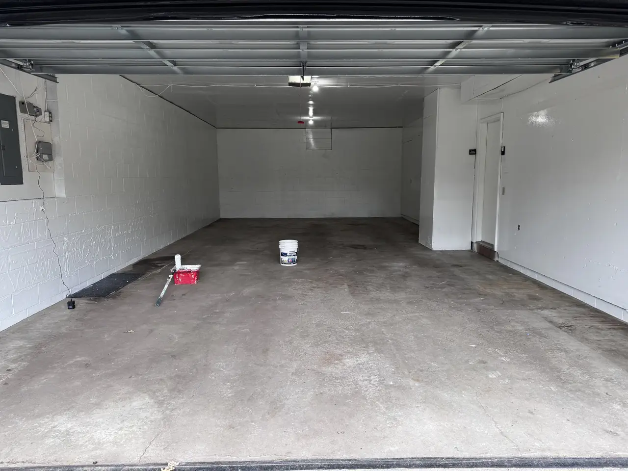 Empty garage interior with freshly painted white walls and concrete floor