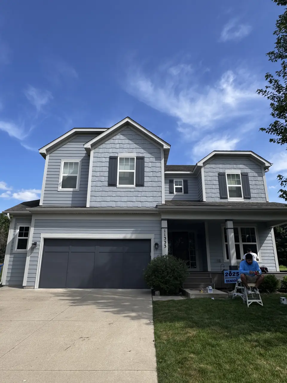 Front elevation of a two-story home with gray siding and a navy garage door