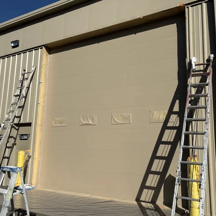 RYA crew masking and prepping a large commercial garage door for exterior painting