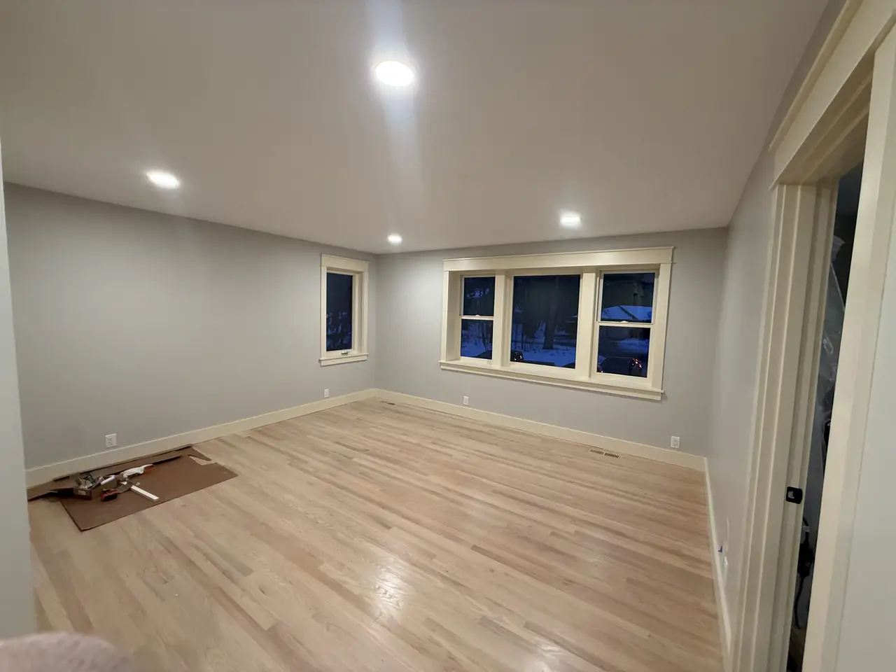 Empty room with freshly refinished hardwood floors and fresh paint on the walls