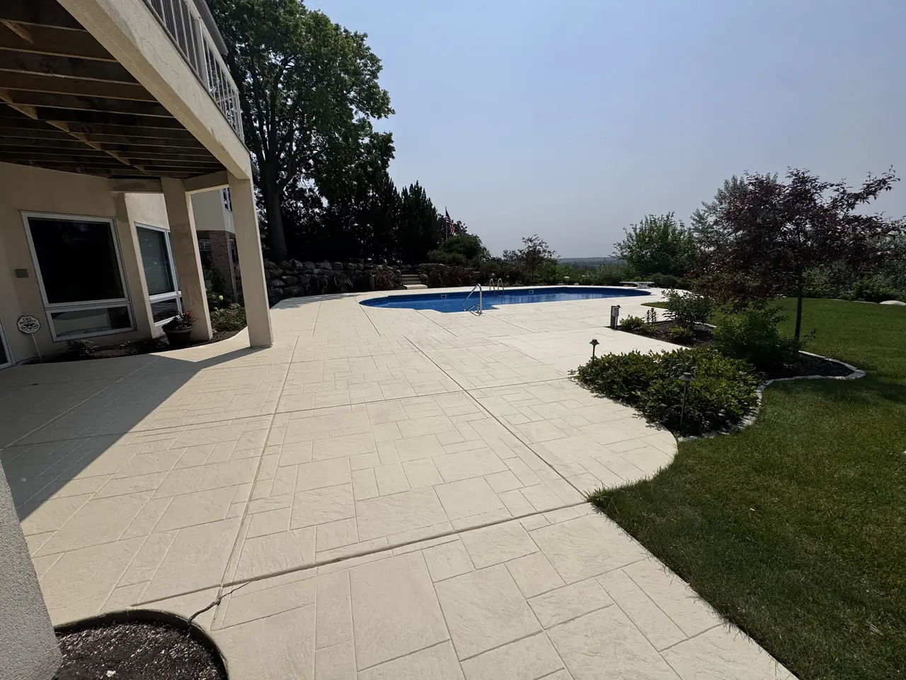Backyard pool and patio area with landscaping at a project property